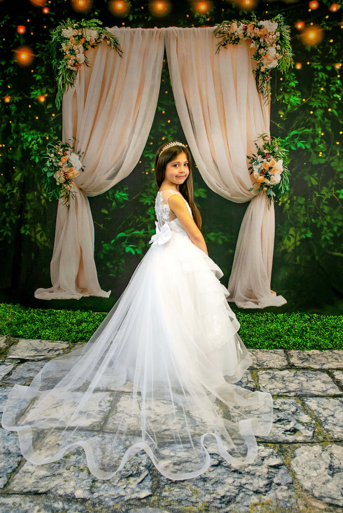 flower girl wearing a flower girl dress in front of wedding arch